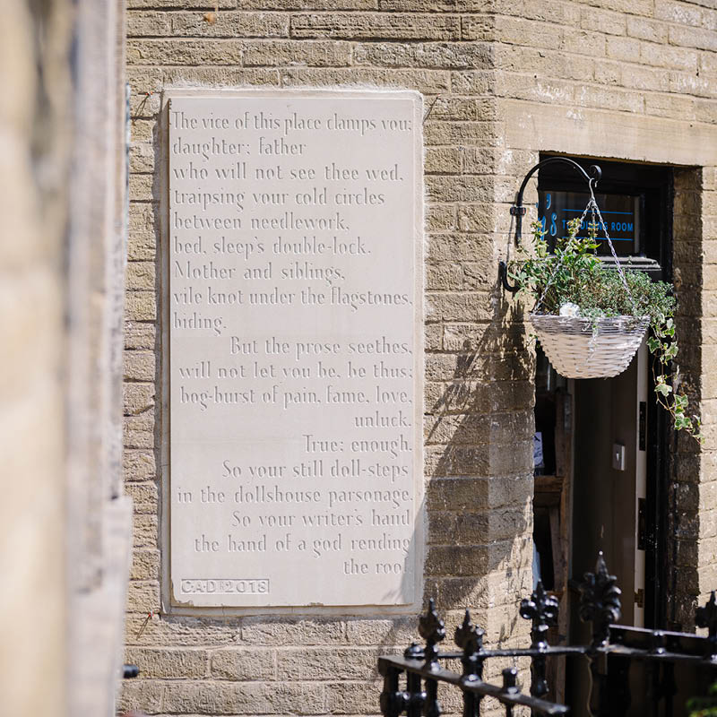 Brontë Stones project: Charlotte Stone mounted on the wall outside Brontë Parsonage Museum