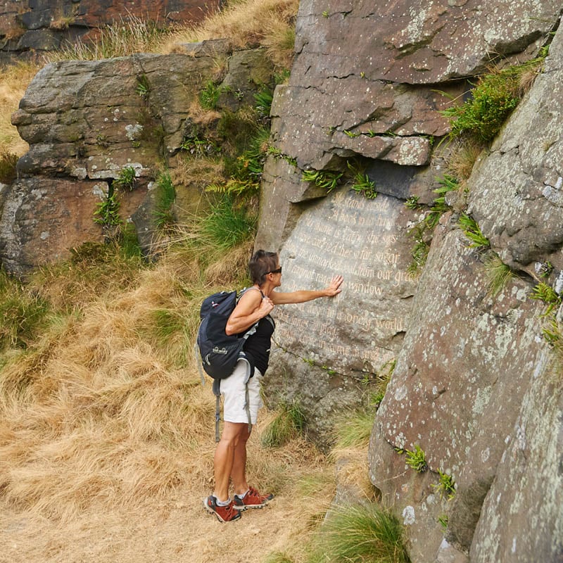 A visitor touching the engraving as part of the Brontë Stones project