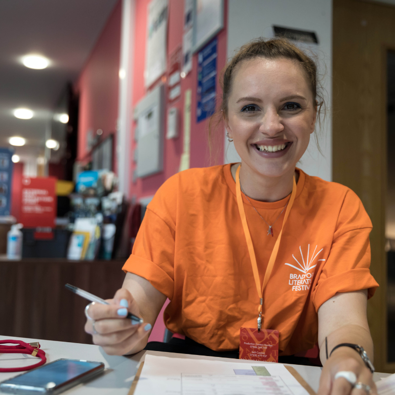 BLF team member smiles at a desk during an event