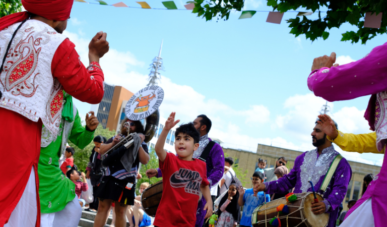 A child dances alongside Punjabi Roots and Fat Cat Brass Band at BLF 2025